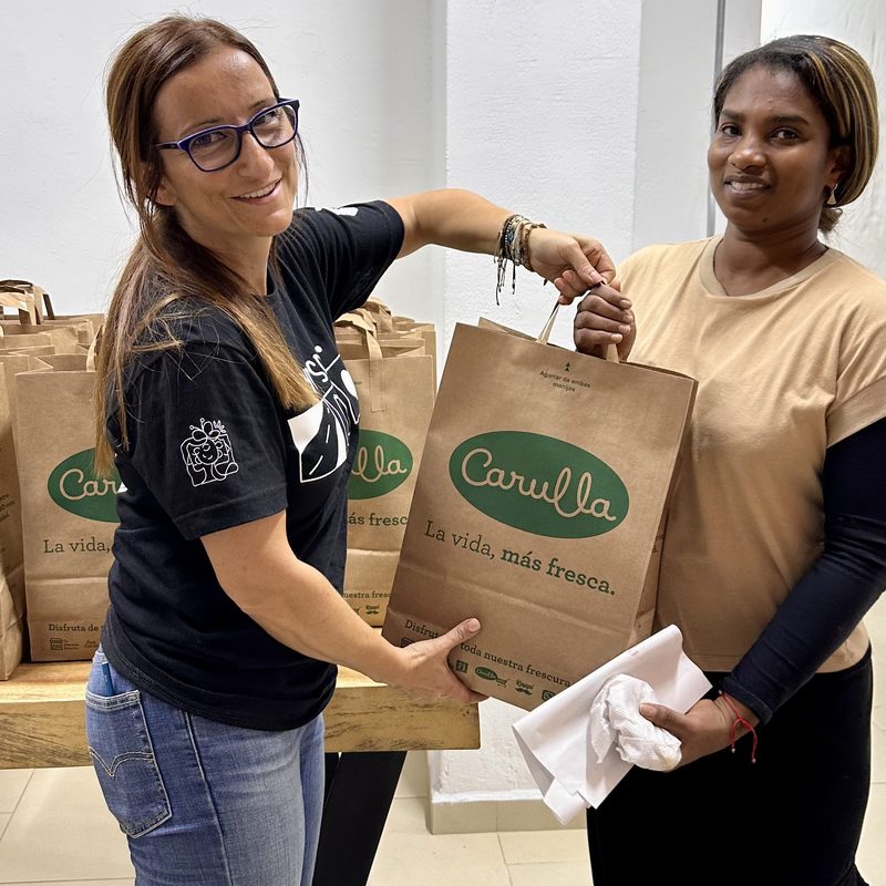 A TIKVA volunteer sharing care and supplies with a woman from the Medellín community